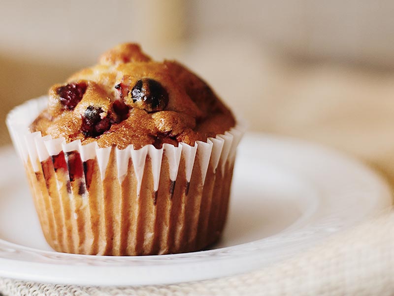 photo of a muffin that is off center on a plate.