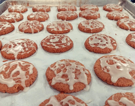 round iced cookies on a baking sheet just out of the oven